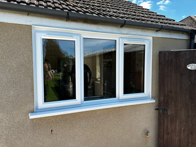 three modern windows with a white frame on a building exterior