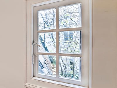 a white window frame with six panes showcasing a view of trees outside