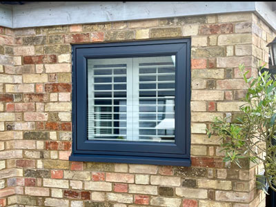 window with shutters on brick wall showing stylish two tone design