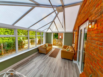 bright and airy sunroom with two cozy sofas surrounded by large windows