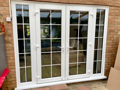 double glass doors with grid design in a brick wall