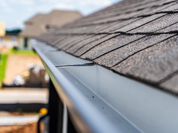 close up of a metal gutter on a shingled roof