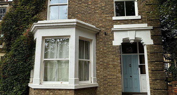 victorian house with ivy exterior and light blue door